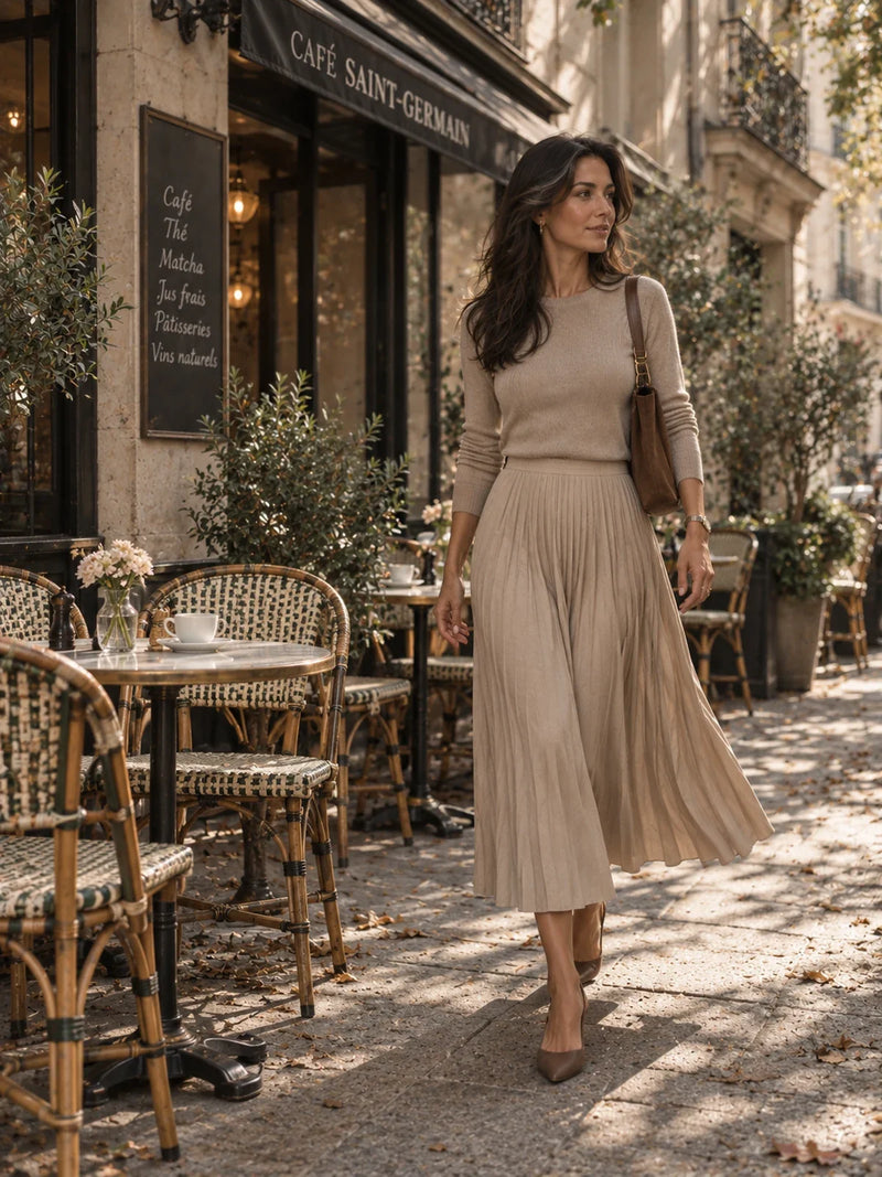 Vrouw in beige plissé midi rok op Parijs caféterras