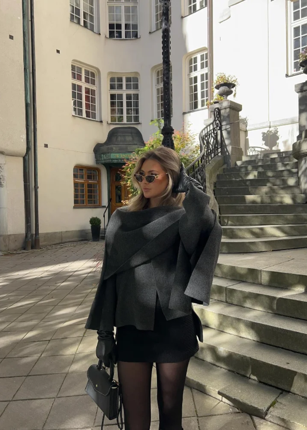 Oversized capejas dames met geïntegreerde sjaal in donkergrijs, gedragen met rok en panty