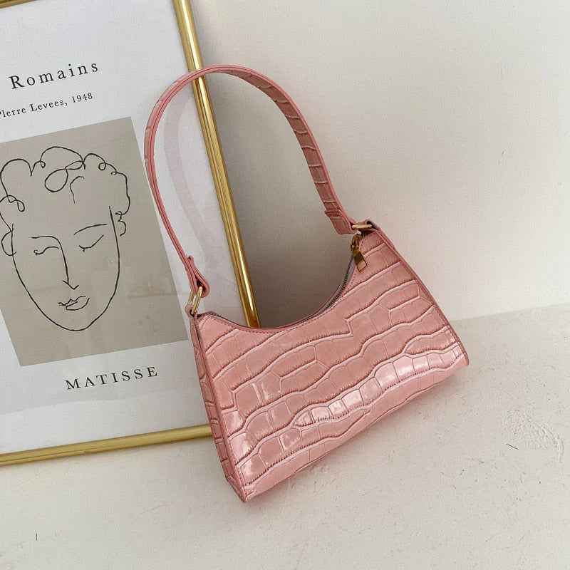 Roze compacte dames schoudertas met krokodillenprint en kort hengsel