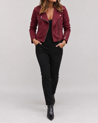 Korte bordeauxrode dames bikerjas op een zwarte broek, volledige look