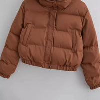 Cropped lengte van de gewatteerde jas, eindigend op taillehoogte