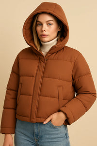 Vrouw in bruine cropped puffer jas met de capuchon op