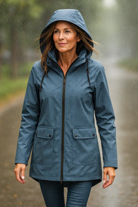 Vrouw in blauwe dames parka met capuchon op een regenachtige dag