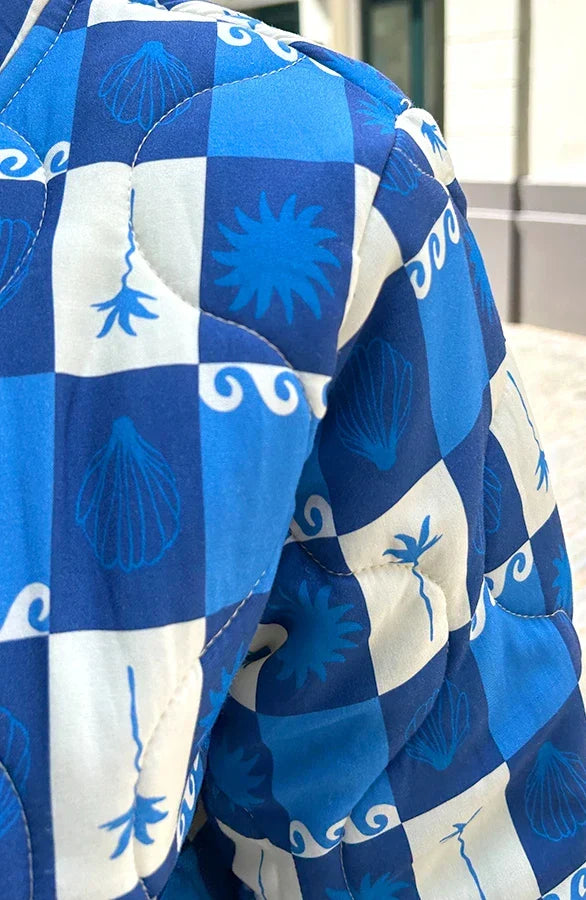 Detail van de blauwe ruitprint met palmbomen en golven