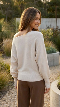 Achterkant van witte gebreide off shoulder trui dames