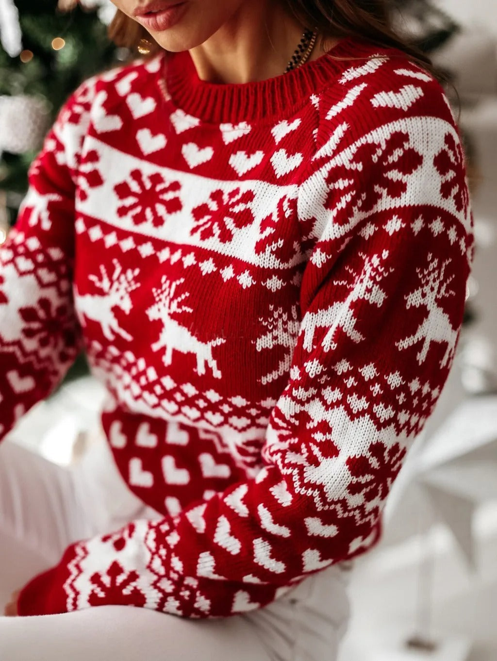Detail van het gebreide rendierpatroon op de rode kersttrui
