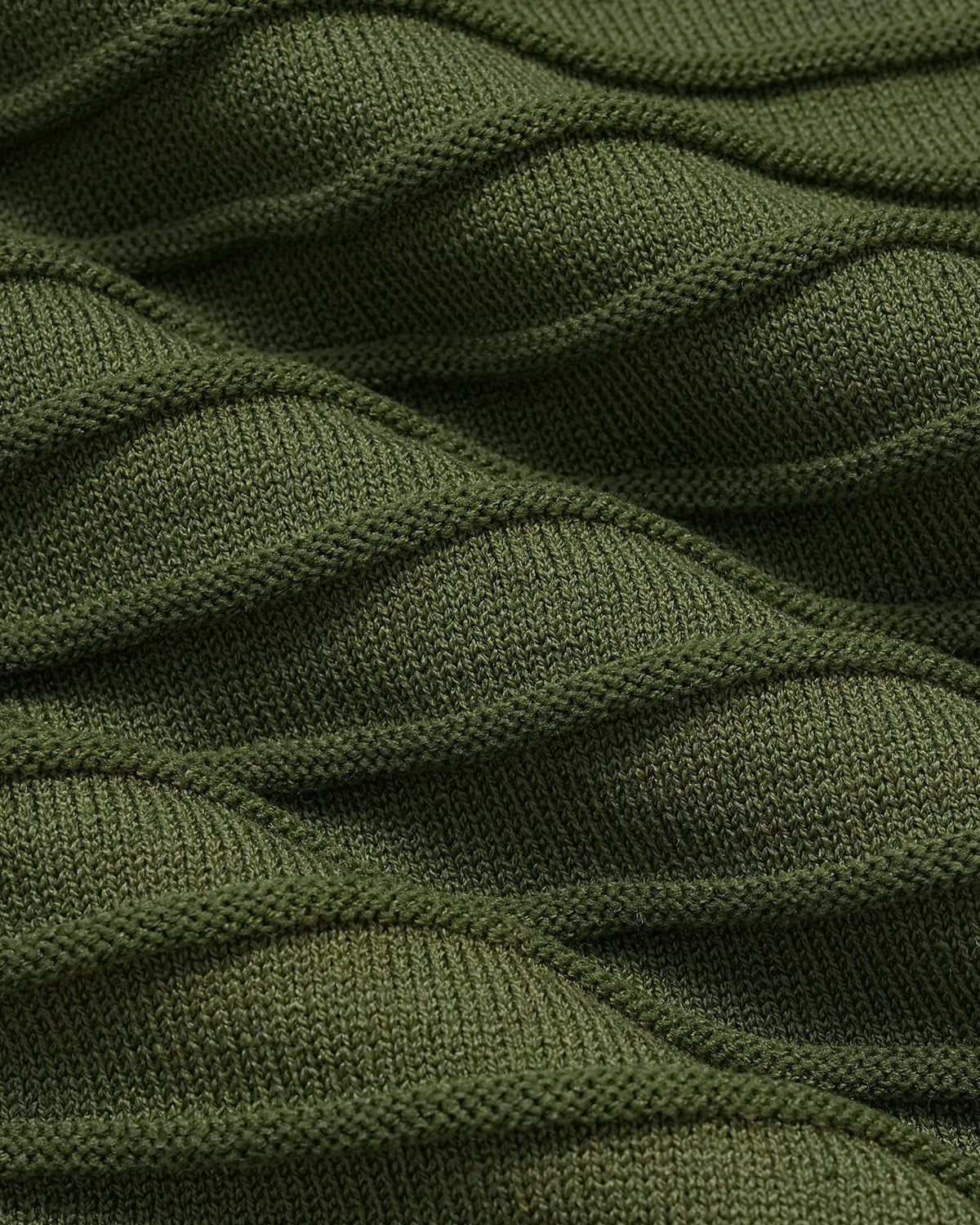 Close-up van het legergroene geribde breiwerk van de midi-jurk