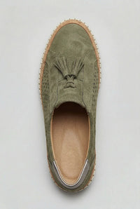 Groene sneaker met kwastjes op de wreef en geperforeerd patroon