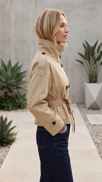 Zijaanzicht van beige trenchcoat dames met hoge staande kraag