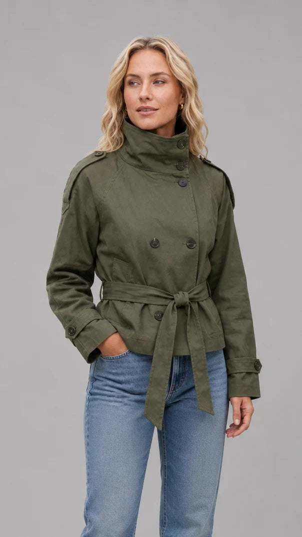 Korte trenchcoat dames in legergroen gedragen op een blauwe jeans