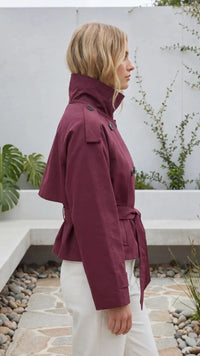 Zijaanzicht van wijnrode trenchcoat dames met mouwbandjes