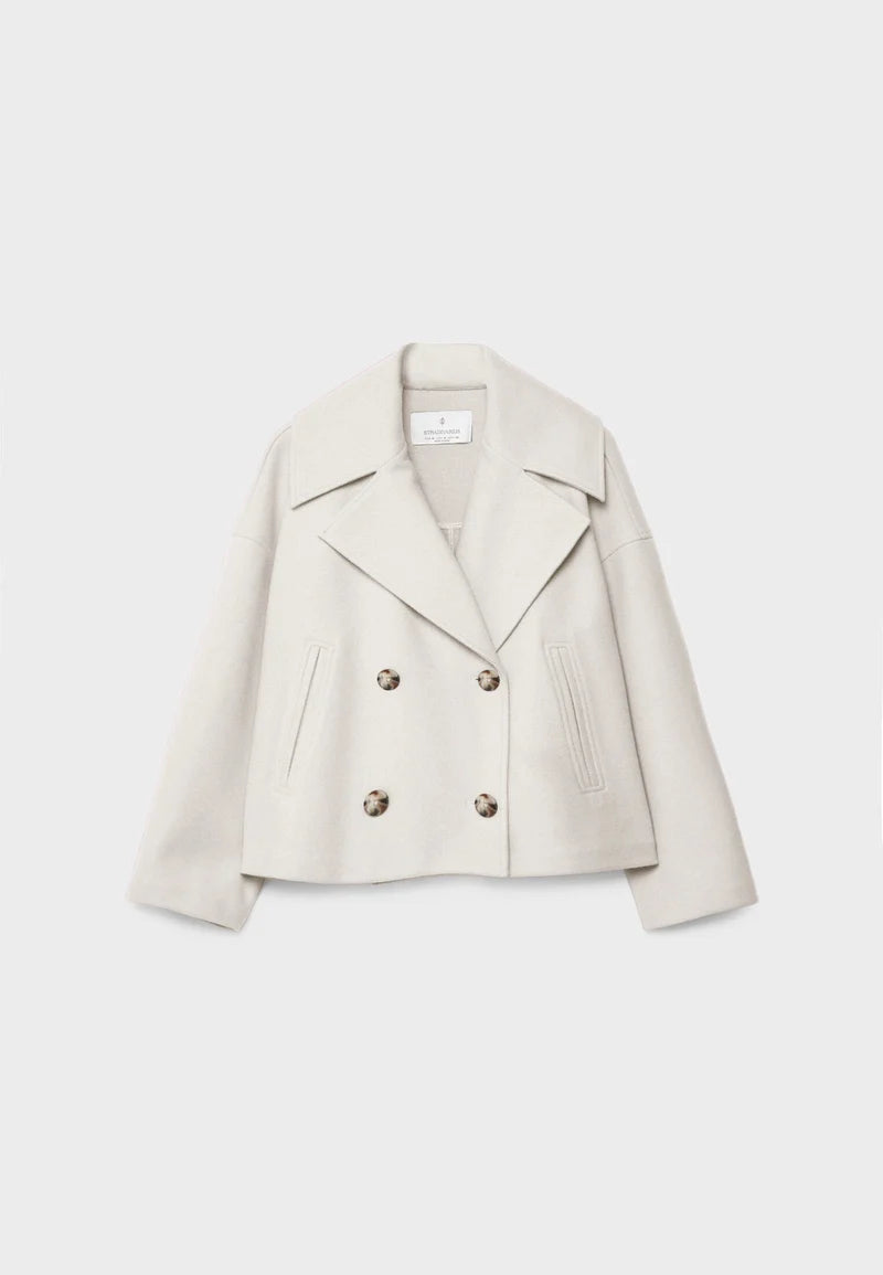 Korte beige damesjas met dubbele rij knopen en steekzakken