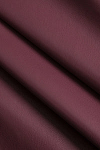 Detail van de imitatieleren stof in burgundy rood
