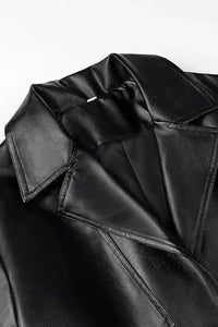Detail van de brede revers en schouderpassant in zwart imitatieleer