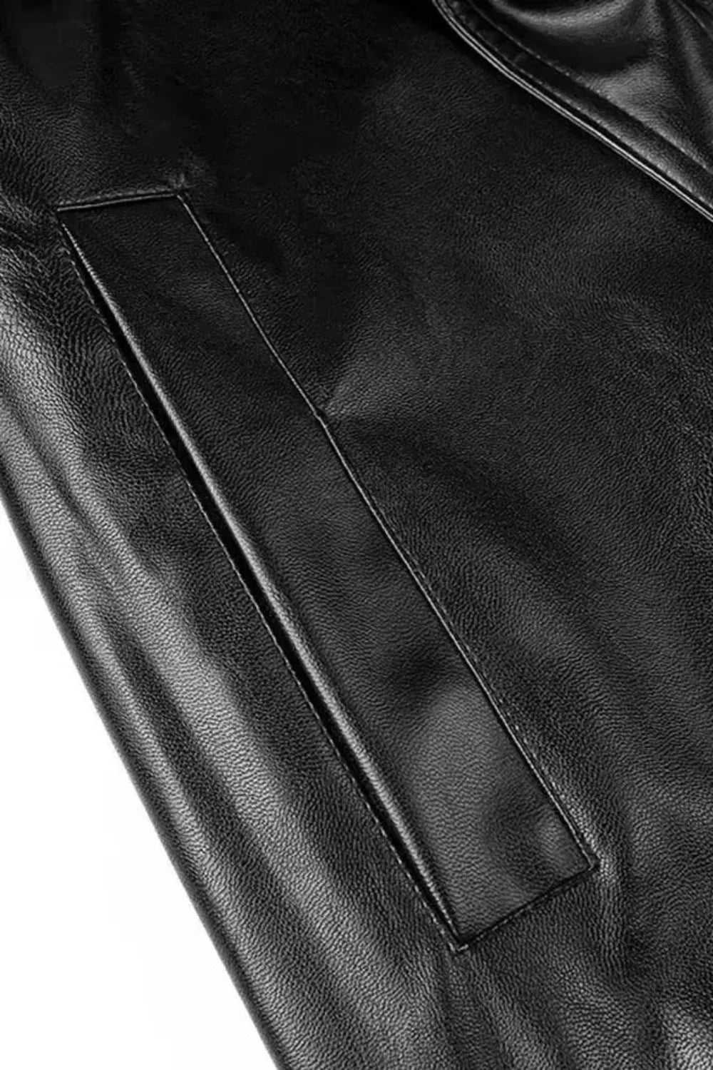 Detail van de zak op de zwarte imitatieleren trenchcoat