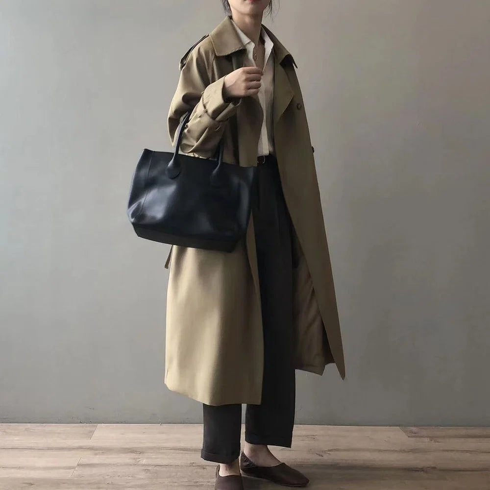 Model draagt een khaki lange dames trenchcoat met reverskraag