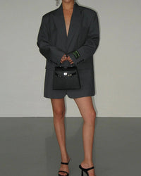 Grijze lange oversized blazer gesloten gedragen als blazerjurk met sandalen