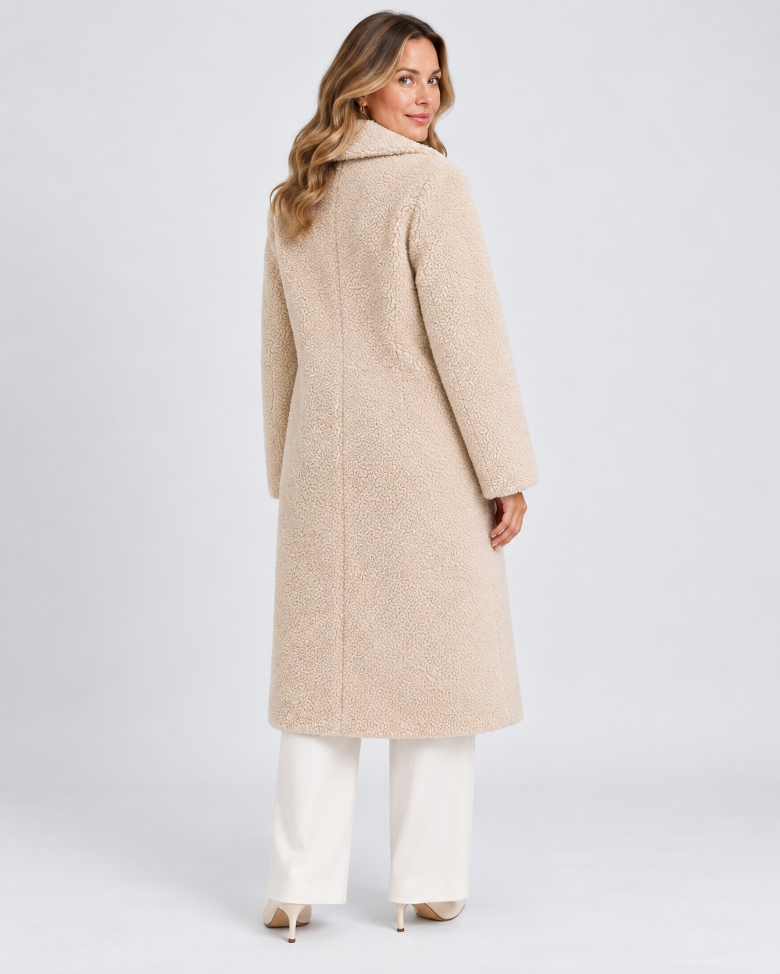 Achterkant van lange beige teddy jas voor dames