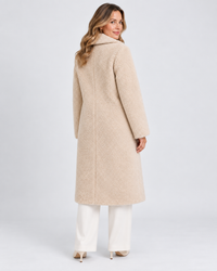 Achterkant van lange beige teddy jas voor dames