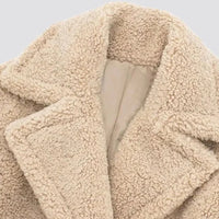 Detail van de krullende teddystof en reverskraag in beige