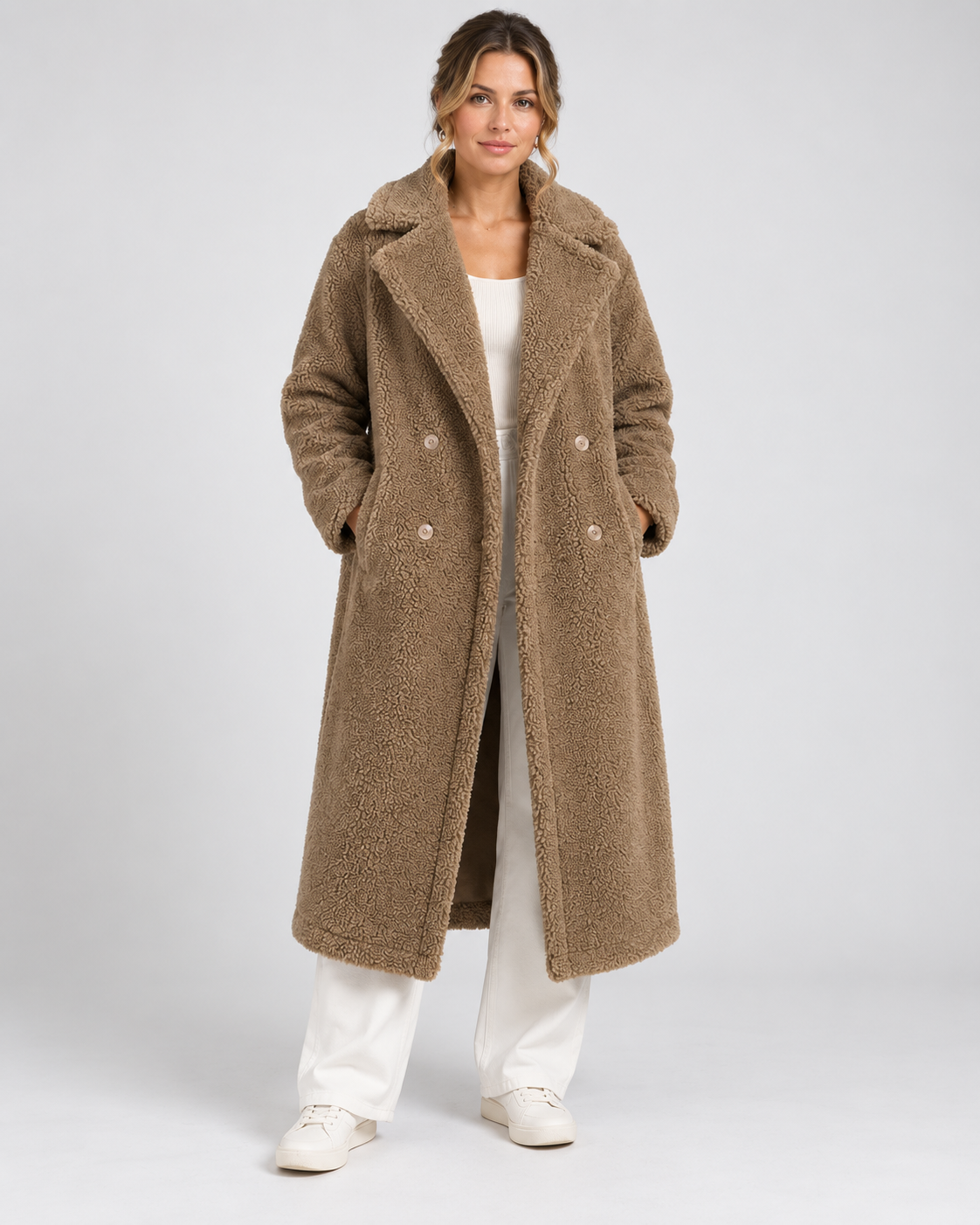 Vrouw in lange taupe teddy jas met dubbele knopenrij, vooraanzicht