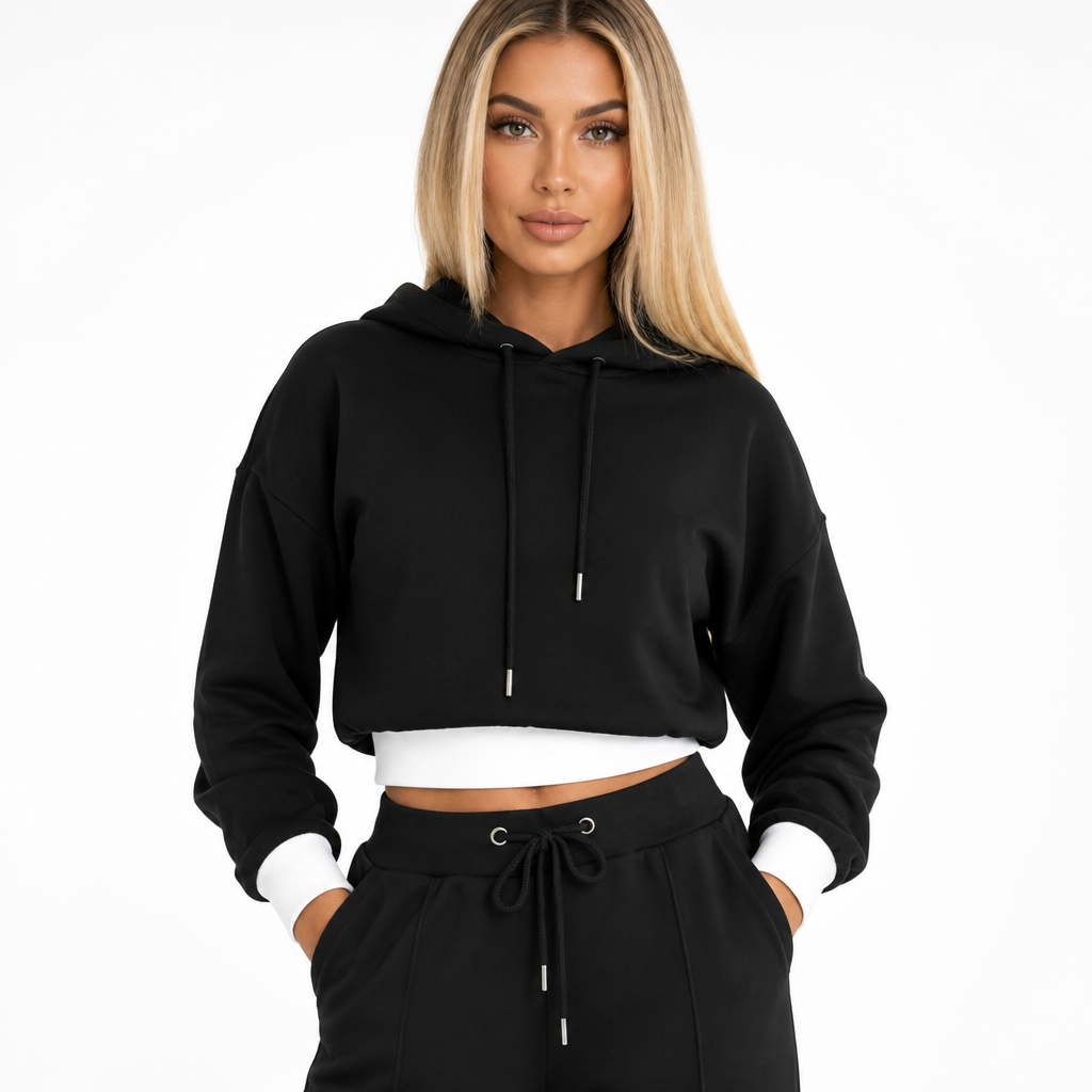 Detail van zwarte cropped hoodie met capuchon, trekkoord en witte manchetten