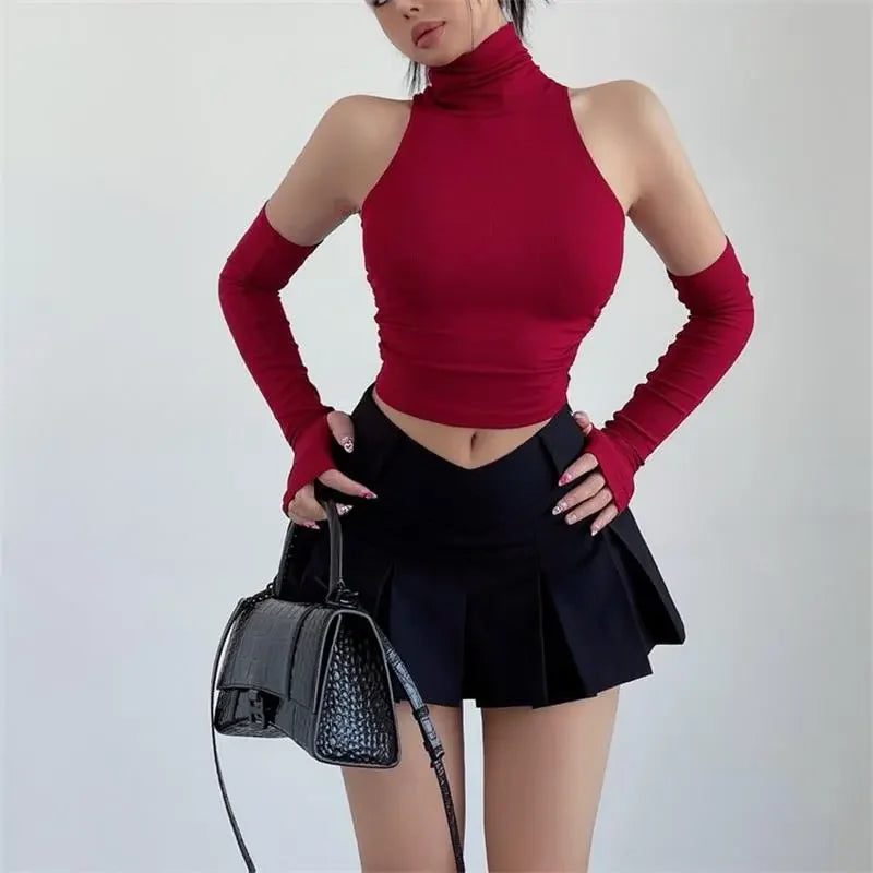 Mouwloze coltop dames met losse armwarmers in rood, gedragen met plissérok