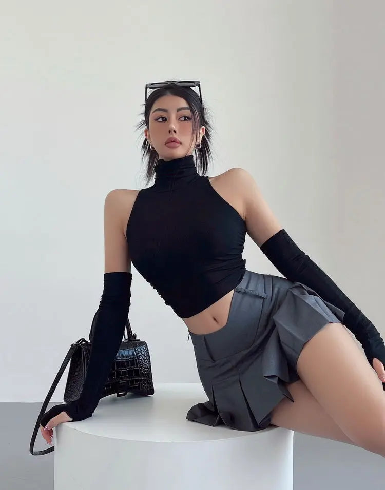 Mouwloze coltop dames met losse armwarmers in zwart, gedragen met plissérok