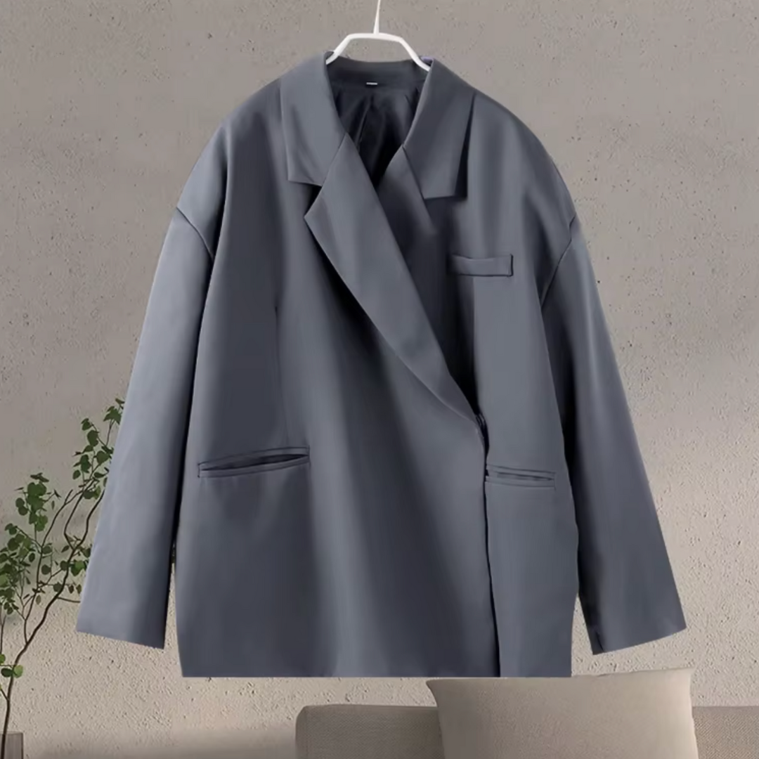 Grijze oversized damesblazer met paspelzakken aan een hanger