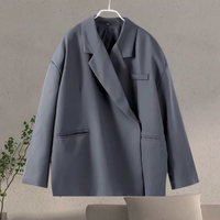 Grijze oversized damesblazer met paspelzakken aan een hanger