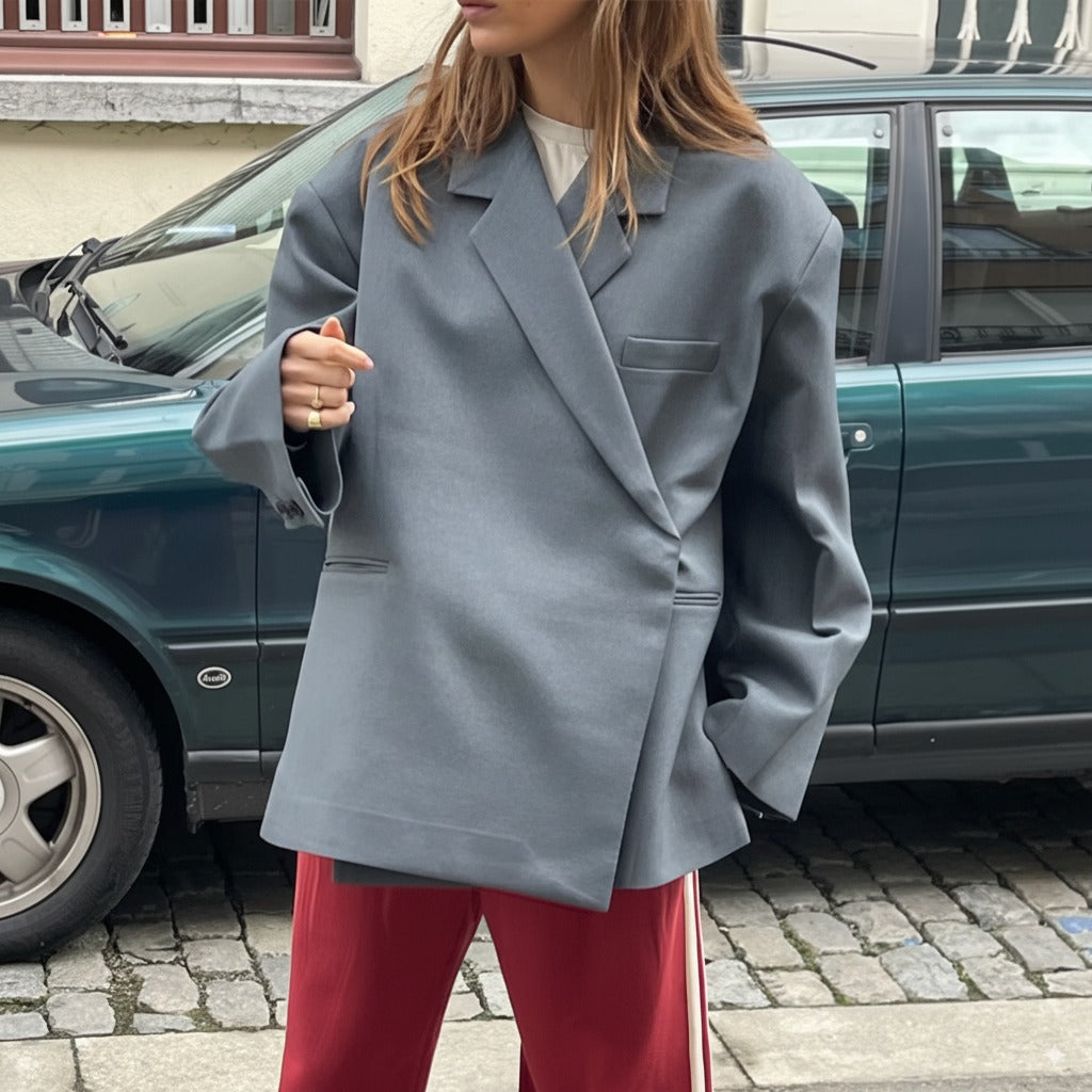 Grijze blazer met diagonale overslag gedragen over een shirt