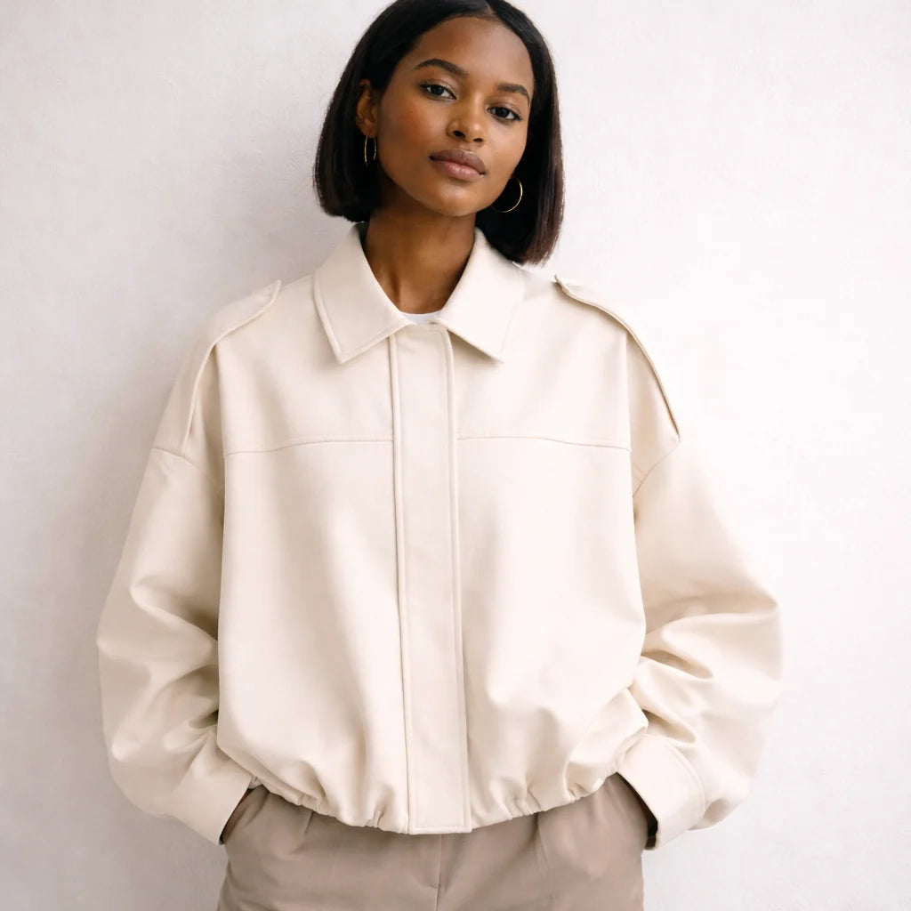 Vrouw in crème oversized jas met puntkraag en wijde mouw