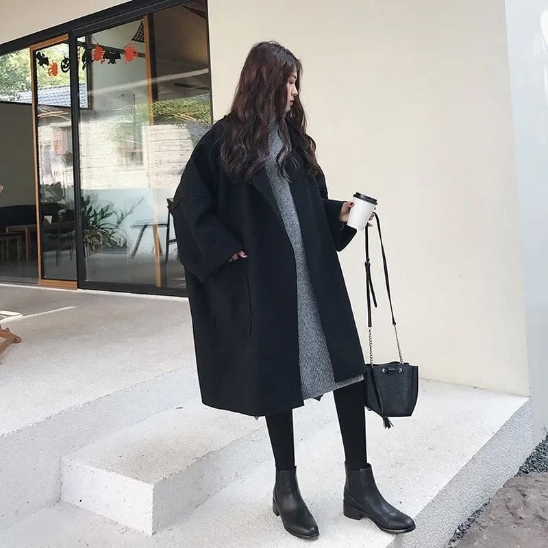 Zwarte oversized dames mantel tot over de knie, gedragen