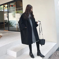 Zwarte oversized dames mantel tot over de knie, gedragen