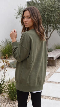 Achterkant van legergroene oversized dames sweater met geribde zoom