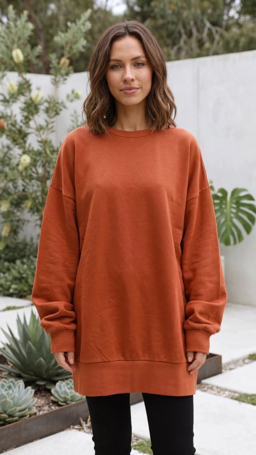 Oranje oversized dames sweater met ronde hals op een zwarte legging