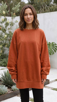 Oranje oversized dames sweater met ronde hals op een zwarte legging