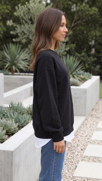 Zijaanzicht van zwarte sweater dames met ruime pasvorm