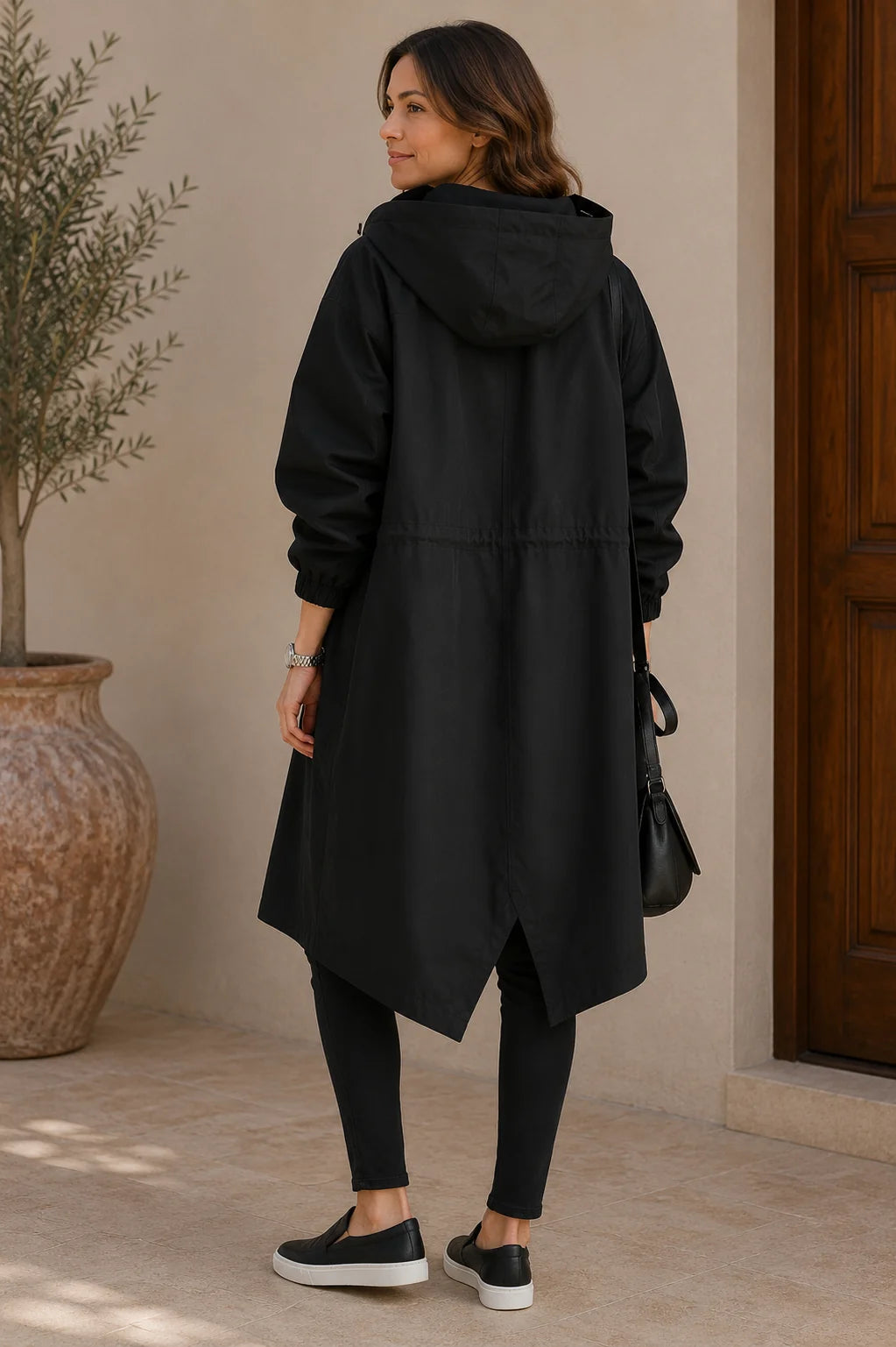 Achterkant van de zwarte oversized jas met capuchon