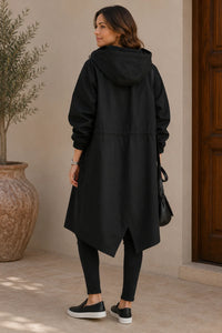 Achterkant van de zwarte oversized jas met capuchon