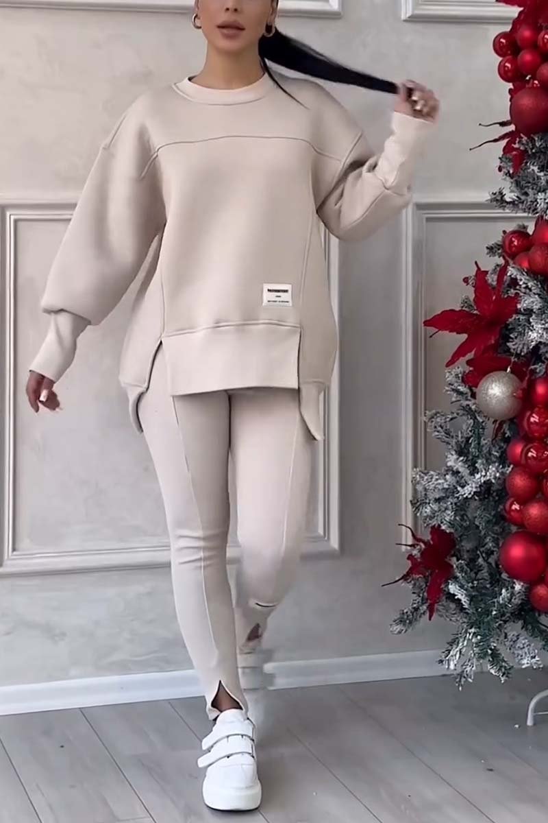Vrouw in beige loungeset met oversized sweater en legging