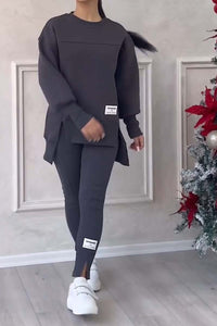 Vrouw in donkergrijze loungeset met oversized sweater en legging