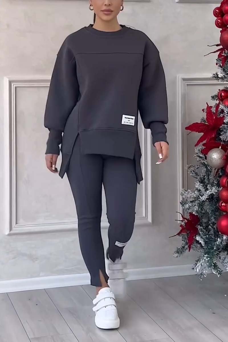 Vrouw in donkergrijze loungeset met oversized sweater en legging