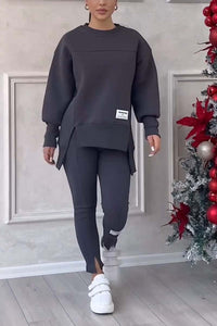Vrouw in donkergrijze loungeset met oversized sweater en legging