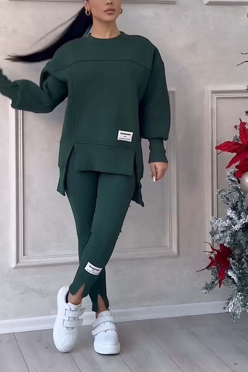 Vrouw in donkergroene loungeset met oversized sweater en legging