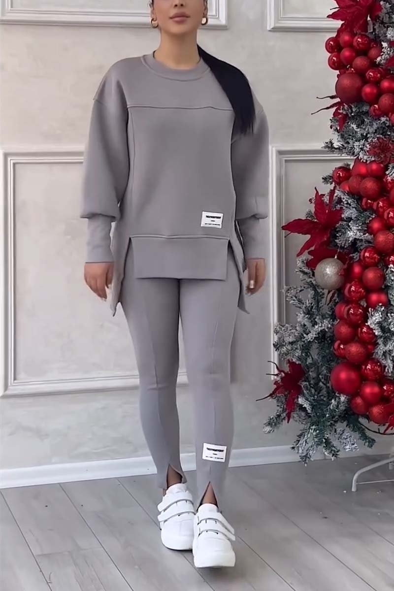 Vrouw in grijze loungeset met oversized sweater en legging