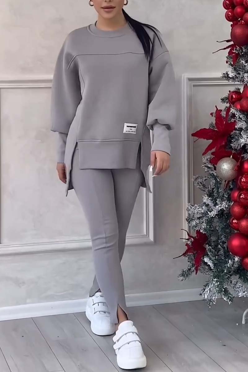 Vrouw in grijze loungeset met oversized sweater en legging