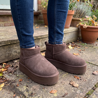 Donkerbruine laarsjes met teddyvoering gedragen bij een jeans buiten