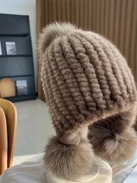 Pluizige oorflapmuts met pompons voor dames in taupe