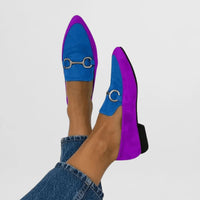 Loafers in blauw en paars naast elkaar met goudkleurig gespdetail